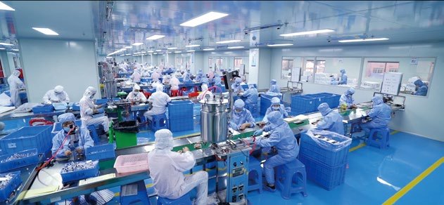 Operators in protective suits working inside the Class 100,000 cleanroom