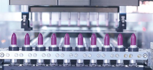 Automatic lip gloss filling line with pink tubes on the conveyor